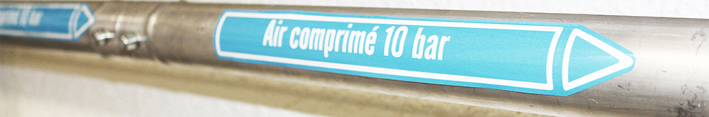 Photo d’étiquettes adhésives marqueurs de tuyauterie bleus correspondant à la matière air comprimée, placés sur un tuyau