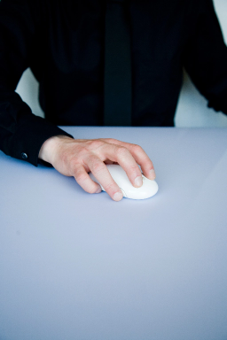 Photo d’une main de quelqu’un vêtu d’une chemise noire utilisant une souris d’ordinateur. 